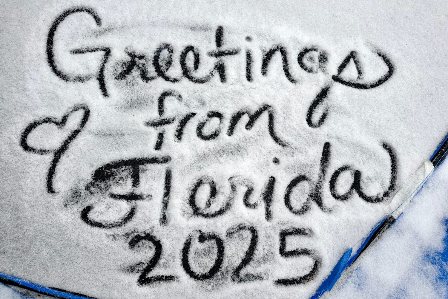 "Greetings from Florida" drawn in the snow.